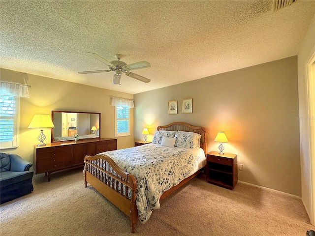 carpeted bedroom with a textured ceiling and ceiling fan