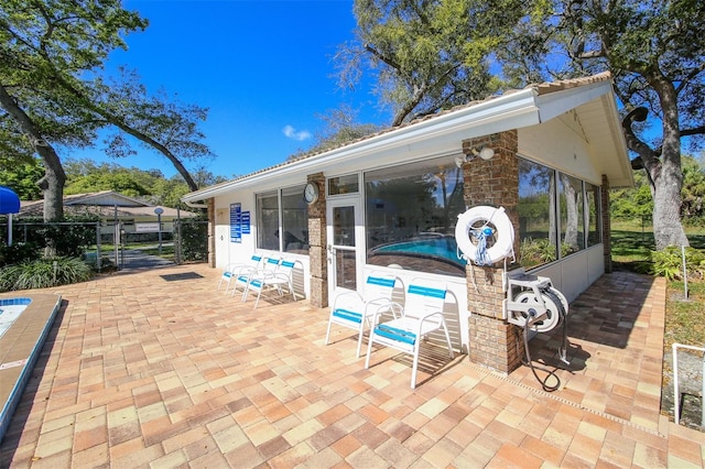 view of patio featuring a sunroom