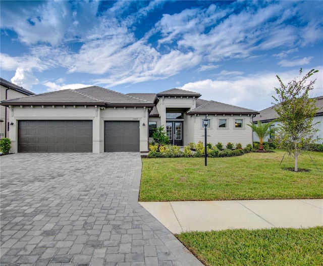 prairie-style home featuring a garage and a front yard