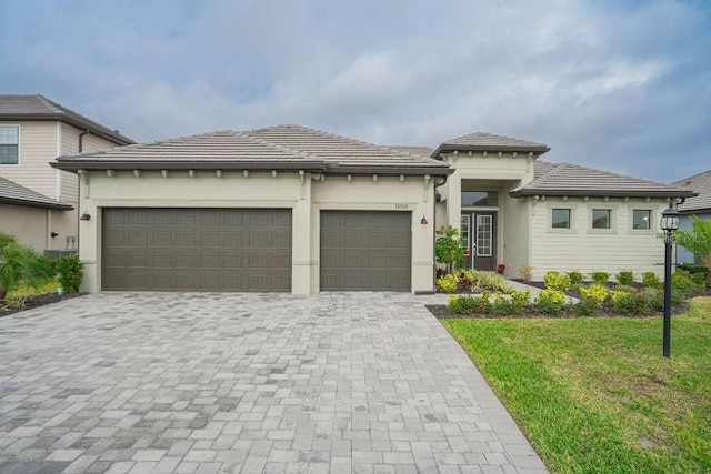 prairie-style home with a garage and a front yard