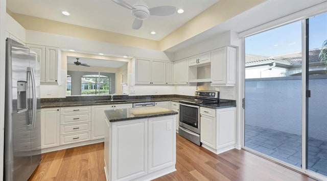 kitchen featuring a center island, white cabinetry, stainless steel appliances, and light hardwood / wood-style flooring