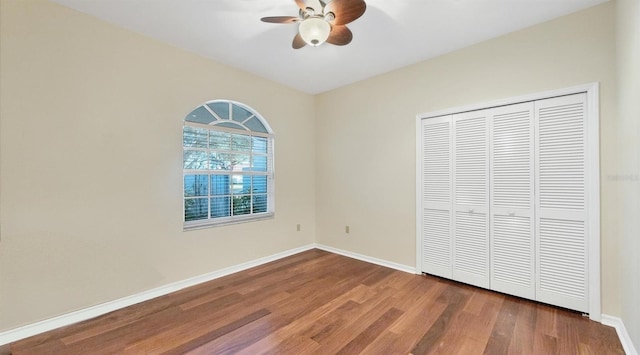 unfurnished bedroom with hardwood / wood-style floors, a closet, and ceiling fan