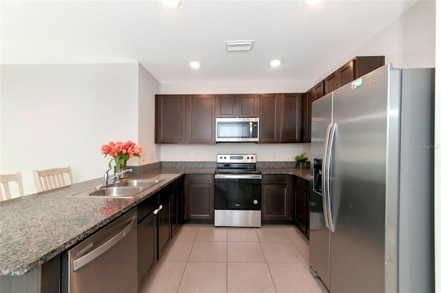 kitchen featuring a kitchen breakfast bar, stainless steel appliances, kitchen peninsula, and sink