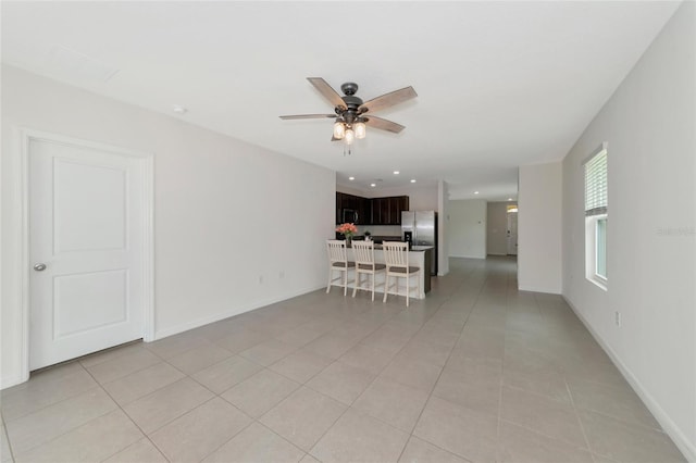 unfurnished living room featuring light tile patterned floors and ceiling fan