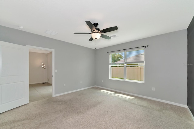 spare room featuring ceiling fan and light colored carpet