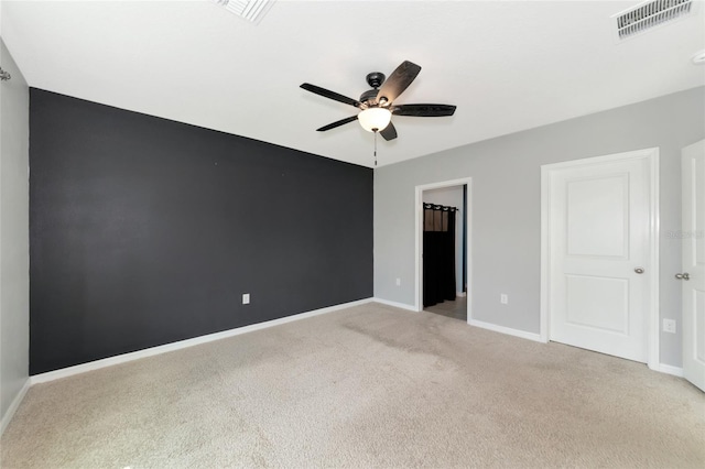 unfurnished bedroom with a walk in closet, ceiling fan, light colored carpet, and a closet