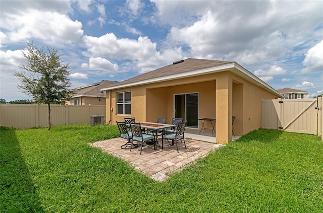 rear view of house with a yard, central AC unit, and a patio area