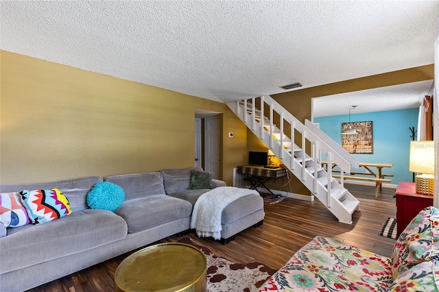 living room with a textured ceiling and dark wood-type flooring