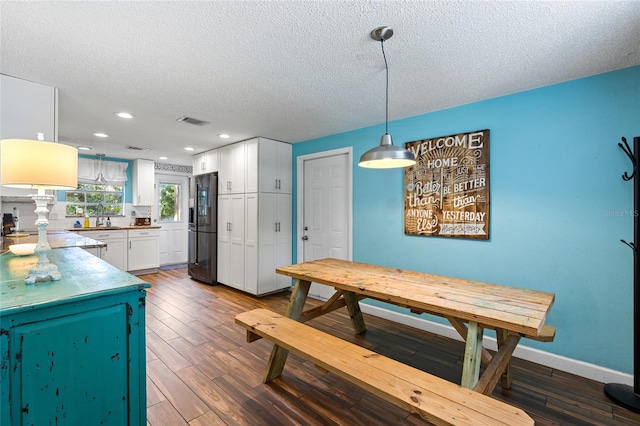 dining room with a textured ceiling and dark hardwood / wood-style floors