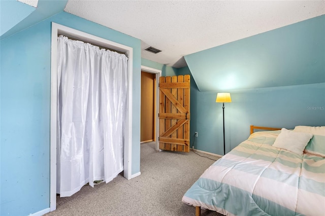 bedroom featuring light carpet, lofted ceiling, and a textured ceiling