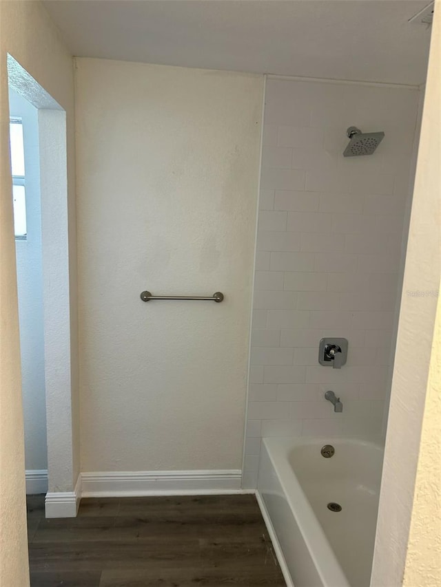 bathroom with hardwood / wood-style floors and tiled shower / bath