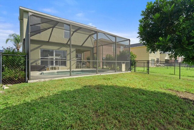 back of house with a fenced in pool, a yard, and glass enclosure