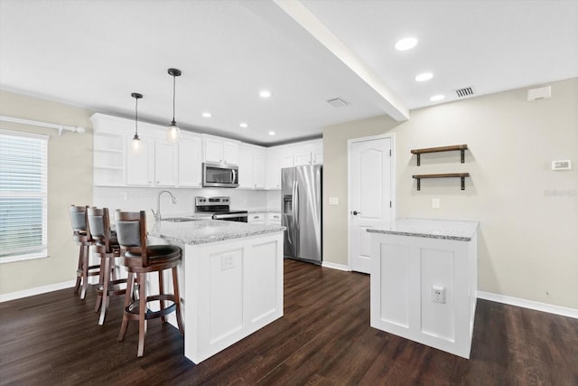 kitchen with appliances with stainless steel finishes, hanging light fixtures, sink, and dark hardwood / wood-style flooring