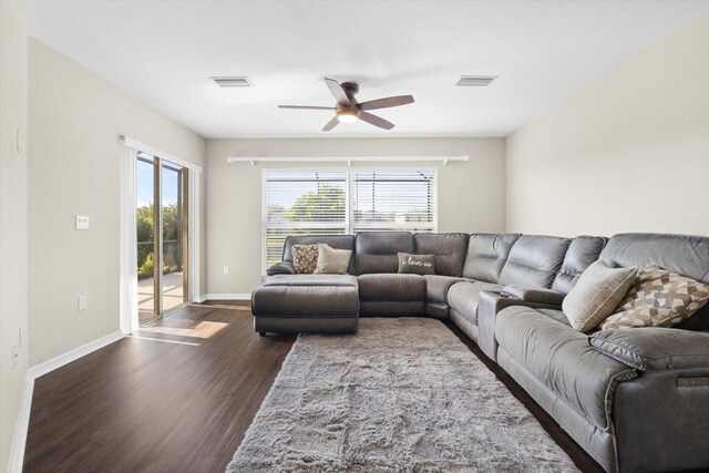 living room featuring ceiling fan and dark hardwood / wood-style floors