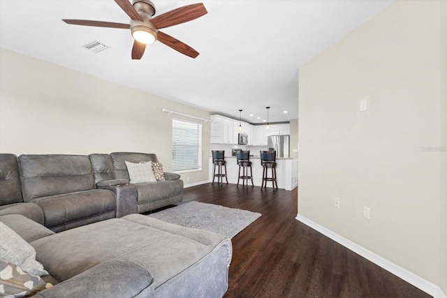 living room featuring dark hardwood / wood-style flooring and ceiling fan