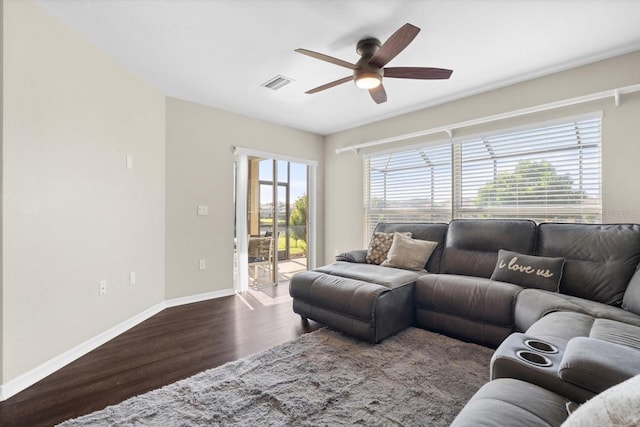 living room featuring dark hardwood / wood-style floors, ceiling fan, and a wealth of natural light