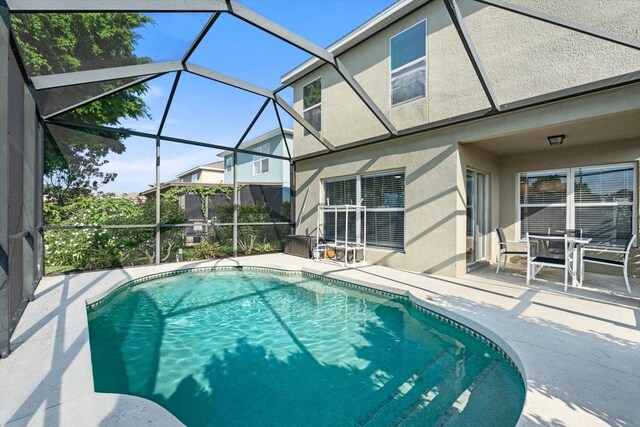 view of swimming pool with a patio and glass enclosure