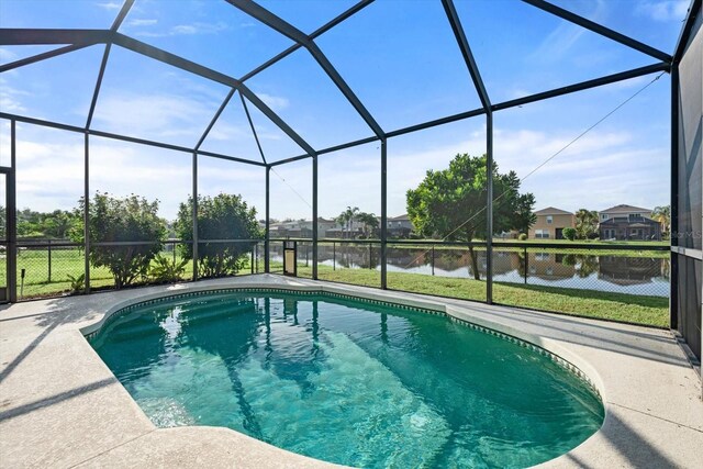 view of swimming pool with a lanai, a yard, and a water view