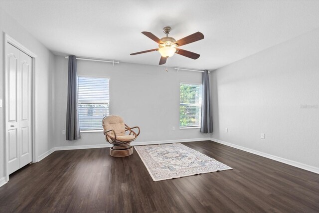 unfurnished room with dark wood-type flooring, ceiling fan, and a wealth of natural light