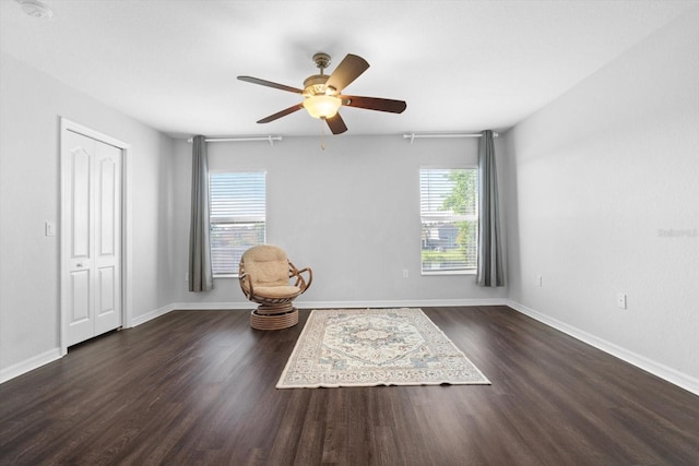 sitting room featuring dark wood-type flooring and ceiling fan