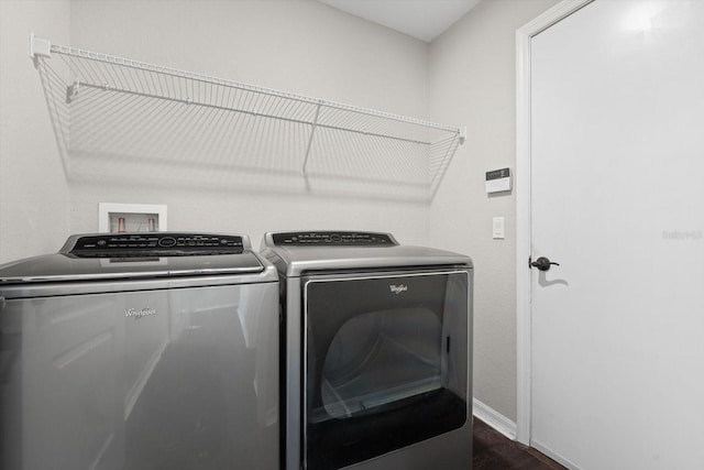 laundry area with washing machine and clothes dryer and dark hardwood / wood-style flooring