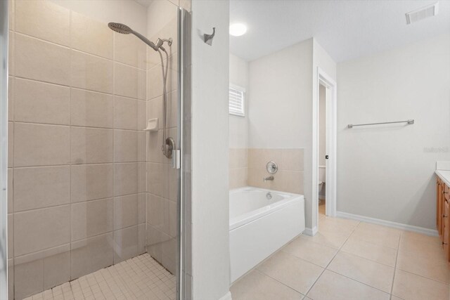 full bathroom featuring tile patterned floors, independent shower and bath, vanity, and toilet