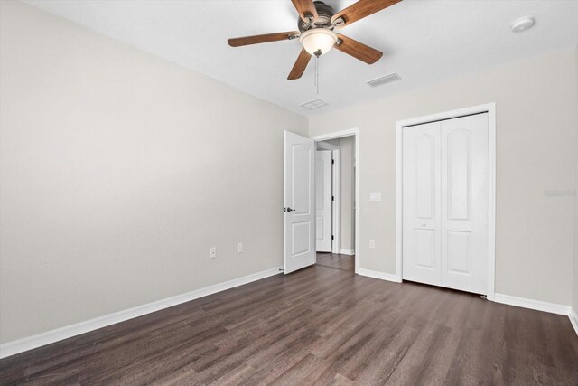 unfurnished bedroom with a closet, ceiling fan, and dark hardwood / wood-style flooring