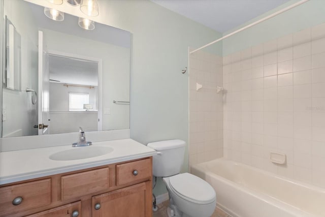 full bathroom featuring tiled shower / bath, vanity, and toilet