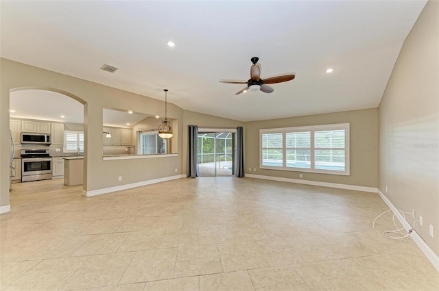 unfurnished living room with ceiling fan, lofted ceiling, and light tile patterned floors