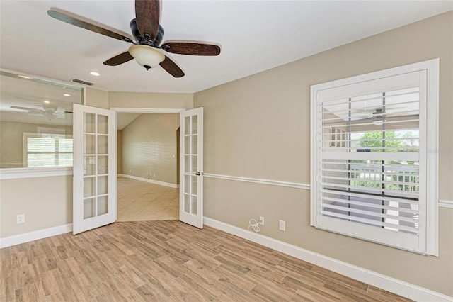 empty room featuring french doors and light hardwood / wood-style floors