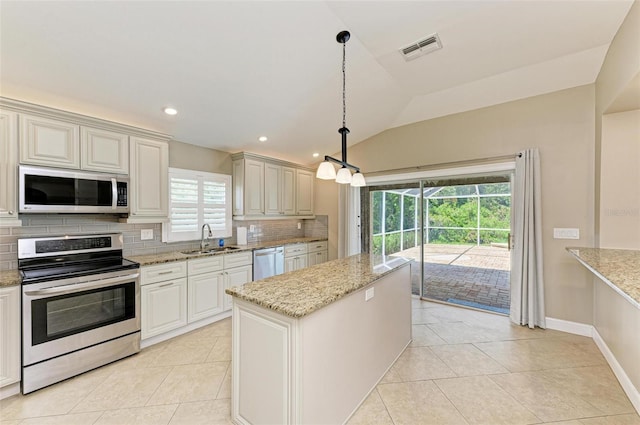 kitchen with sink, vaulted ceiling, appliances with stainless steel finishes, tasteful backsplash, and decorative light fixtures