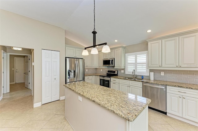 kitchen featuring sink, hanging light fixtures, vaulted ceiling, a kitchen island, and stainless steel appliances