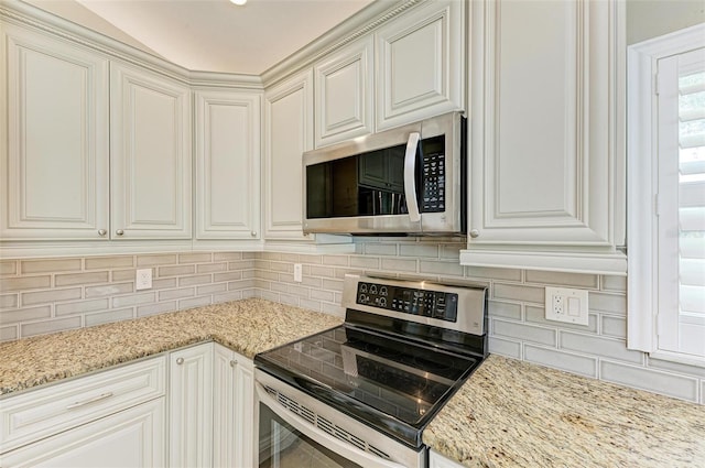 kitchen featuring backsplash, light stone counters, and stainless steel appliances