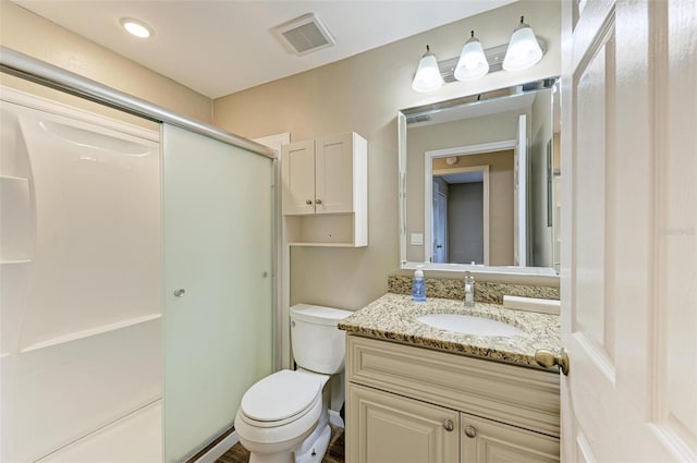 bathroom featuring toilet, an enclosed shower, and vanity