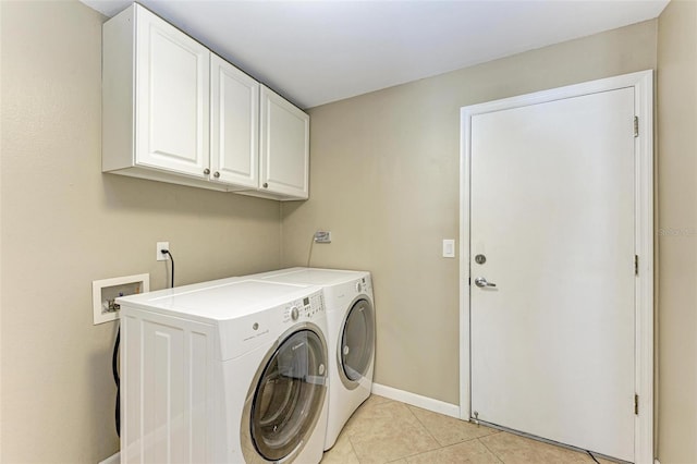 laundry area featuring cabinets, washer and clothes dryer, and light tile patterned flooring