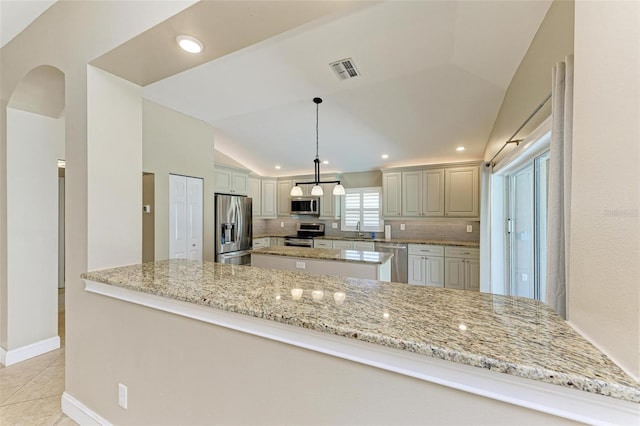 kitchen with tasteful backsplash, kitchen peninsula, stainless steel appliances, and lofted ceiling