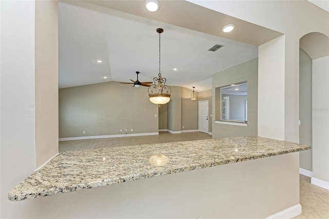 kitchen with ceiling fan, light stone counters, pendant lighting, vaulted ceiling, and light tile patterned flooring