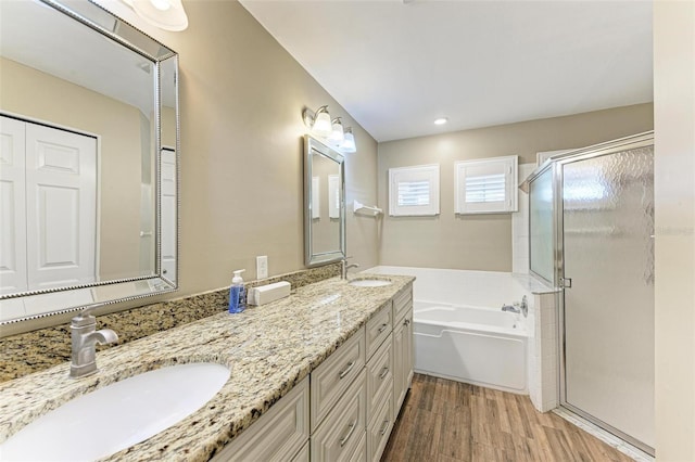 bathroom featuring plus walk in shower, wood-type flooring, and vanity