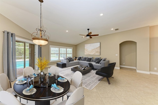 dining space featuring ceiling fan, light tile patterned floors, and vaulted ceiling