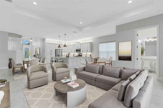 living room featuring sink and a tray ceiling