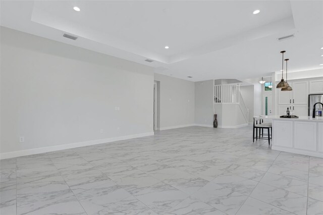 unfurnished living room featuring a raised ceiling