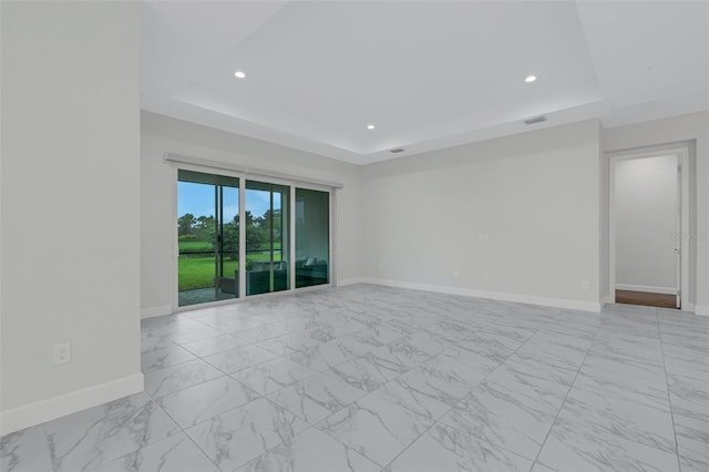 spare room with a tray ceiling