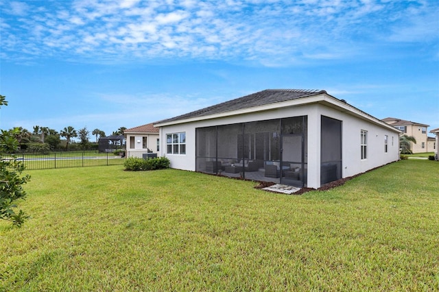 rear view of property with a sunroom and a lawn