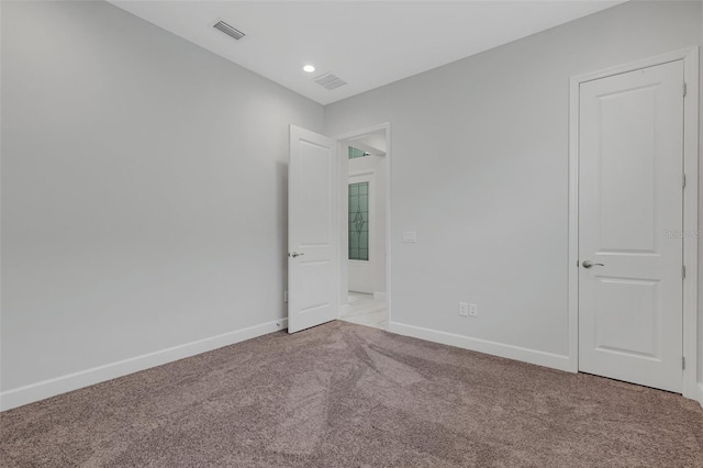 spare room featuring light colored carpet