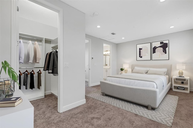 carpeted bedroom with a closet and ensuite bath