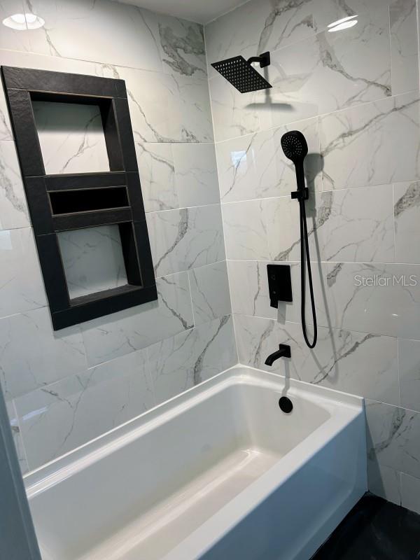 bathroom with tiled shower / bath combo