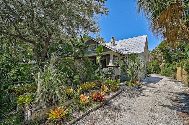 1677 4th St, Sarasota, FL 34236 - view of front of property featuring metal roof, covered porch, driveway, and a chimney
