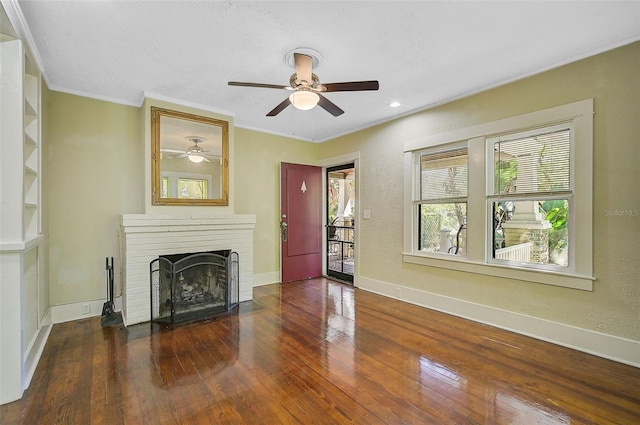 unfurnished living room with a textured ceiling, a fireplace, dark hardwood / wood-style flooring, ornamental molding, and ceiling fan