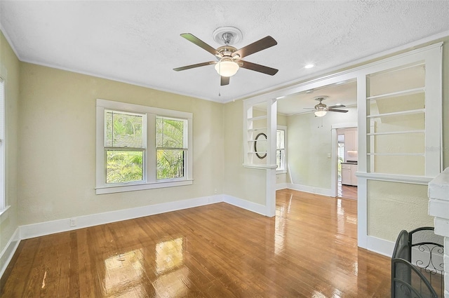 spare room with a textured ceiling, hardwood / wood-style floors, and ceiling fan