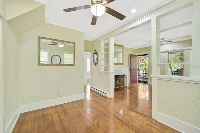 unfurnished room with ceiling fan, a baseboard radiator, ornamental molding, and wood-type flooring